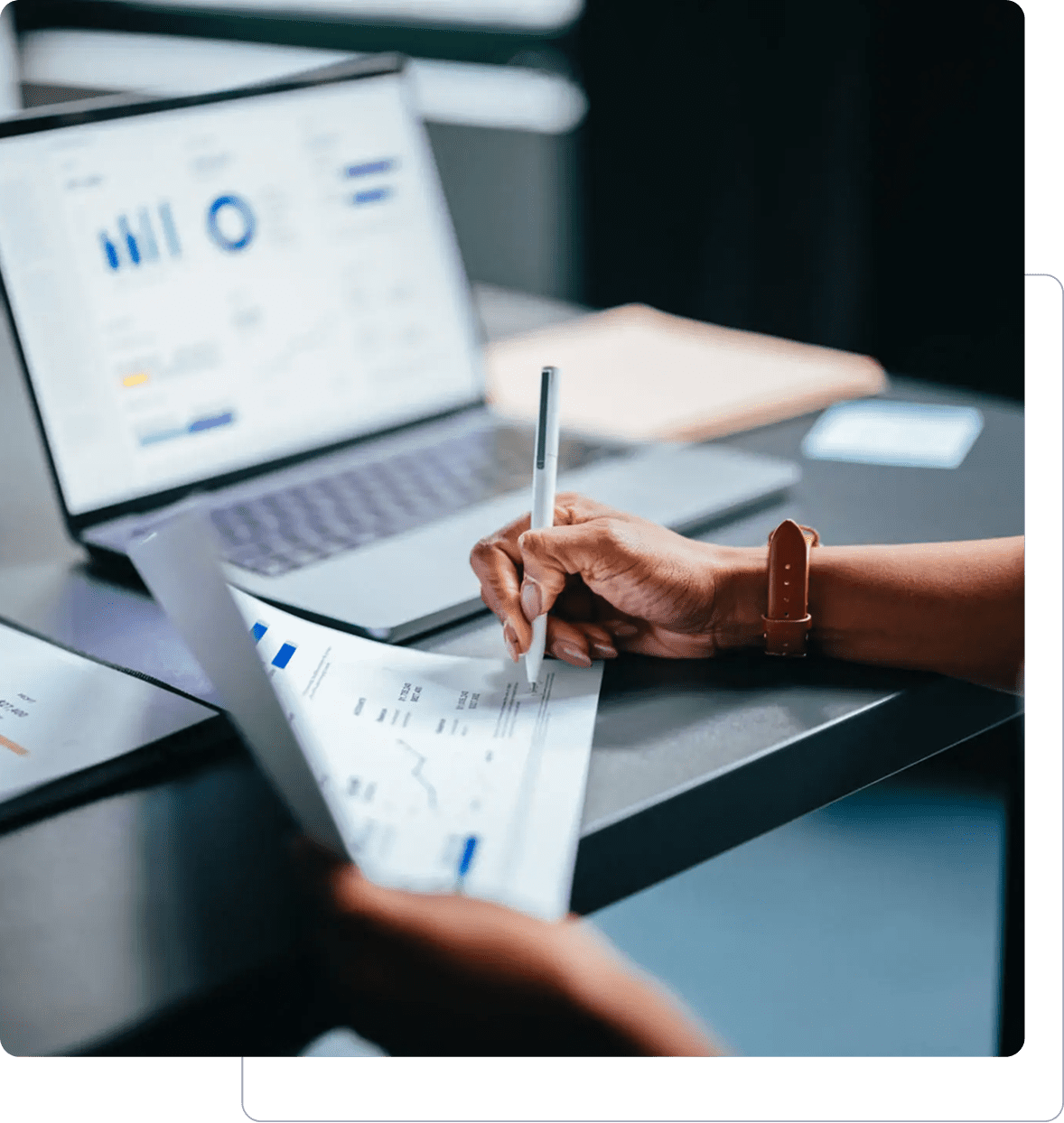 Person analyzing data on laptop and paper.